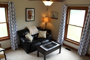 Room with leather couch between windows